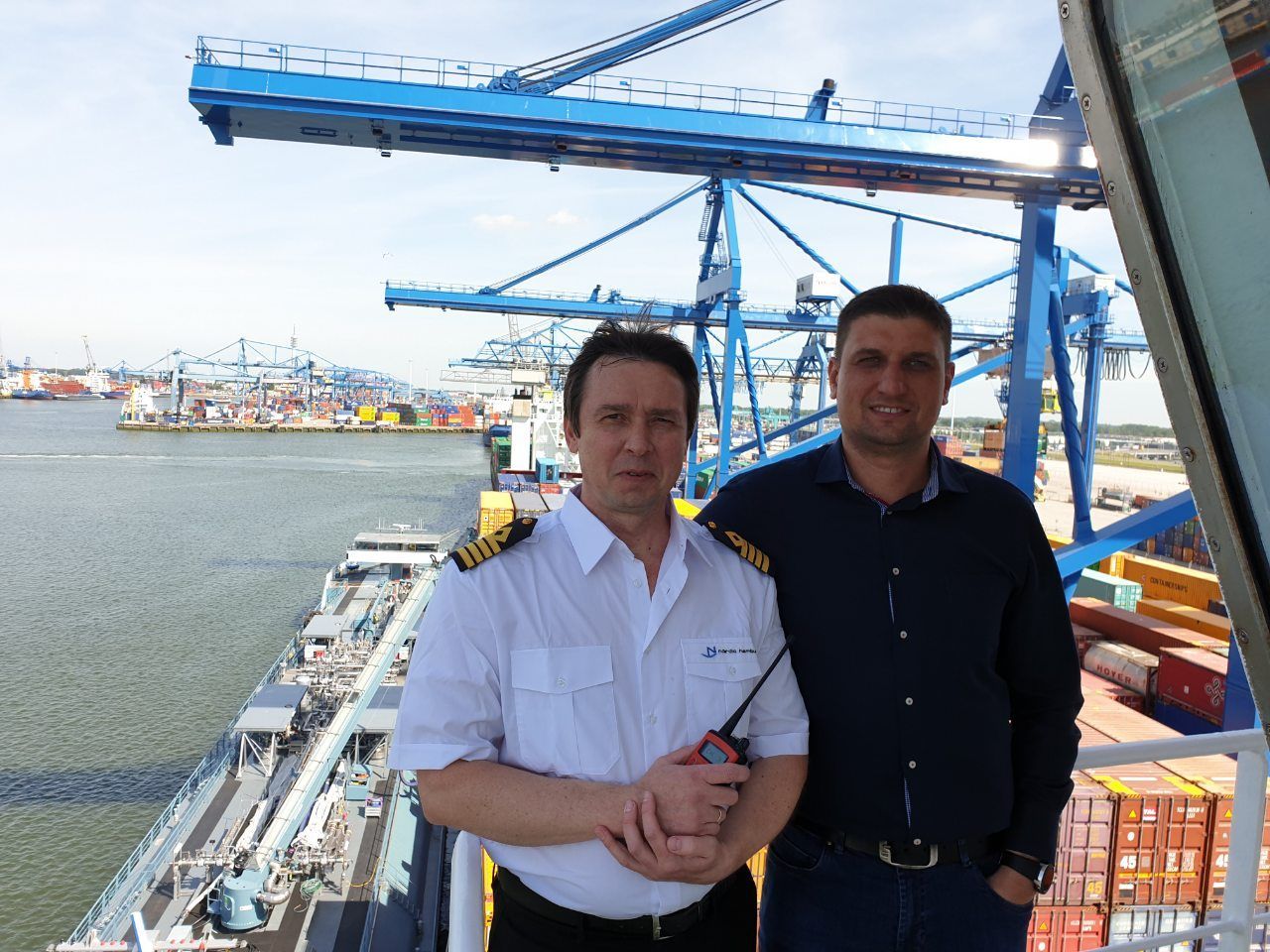 Ship's Master and coworker standing on a vessel moored at a port