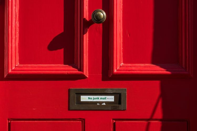Red front door with a sign saying 'no junk mail'