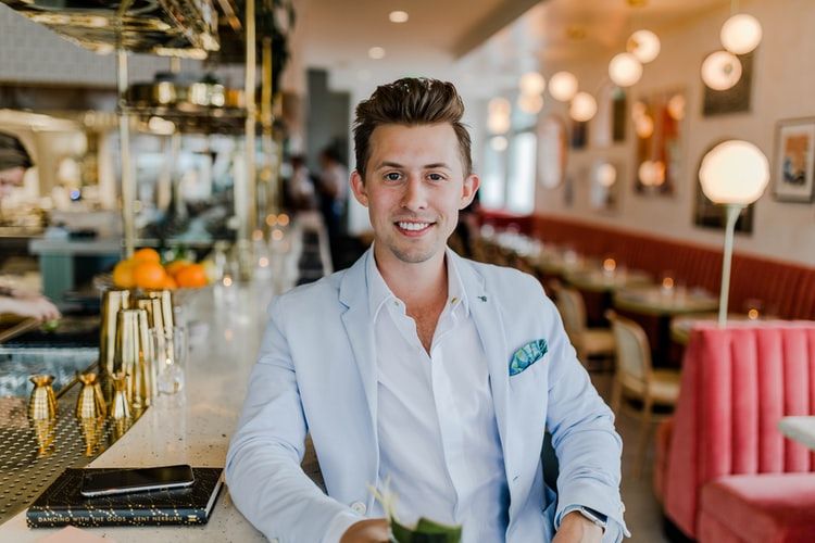 Smiling man in casual business attire sitting in a bar