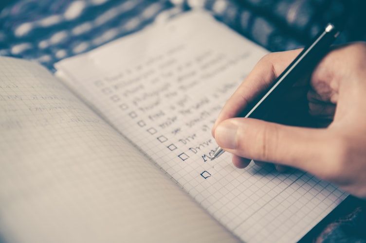 Hand writing a checklist in a notebook