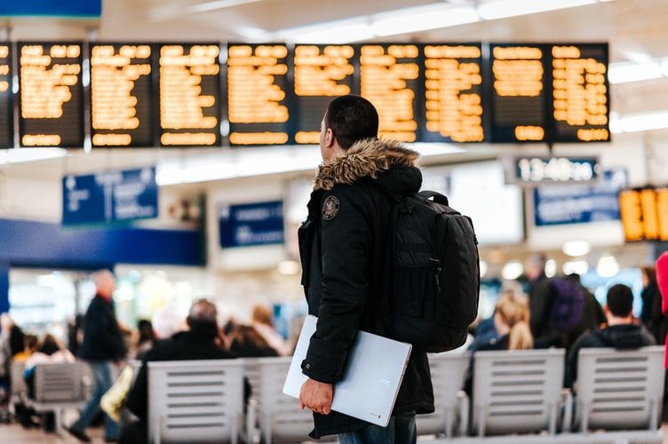 Man in airport looking at departures board
