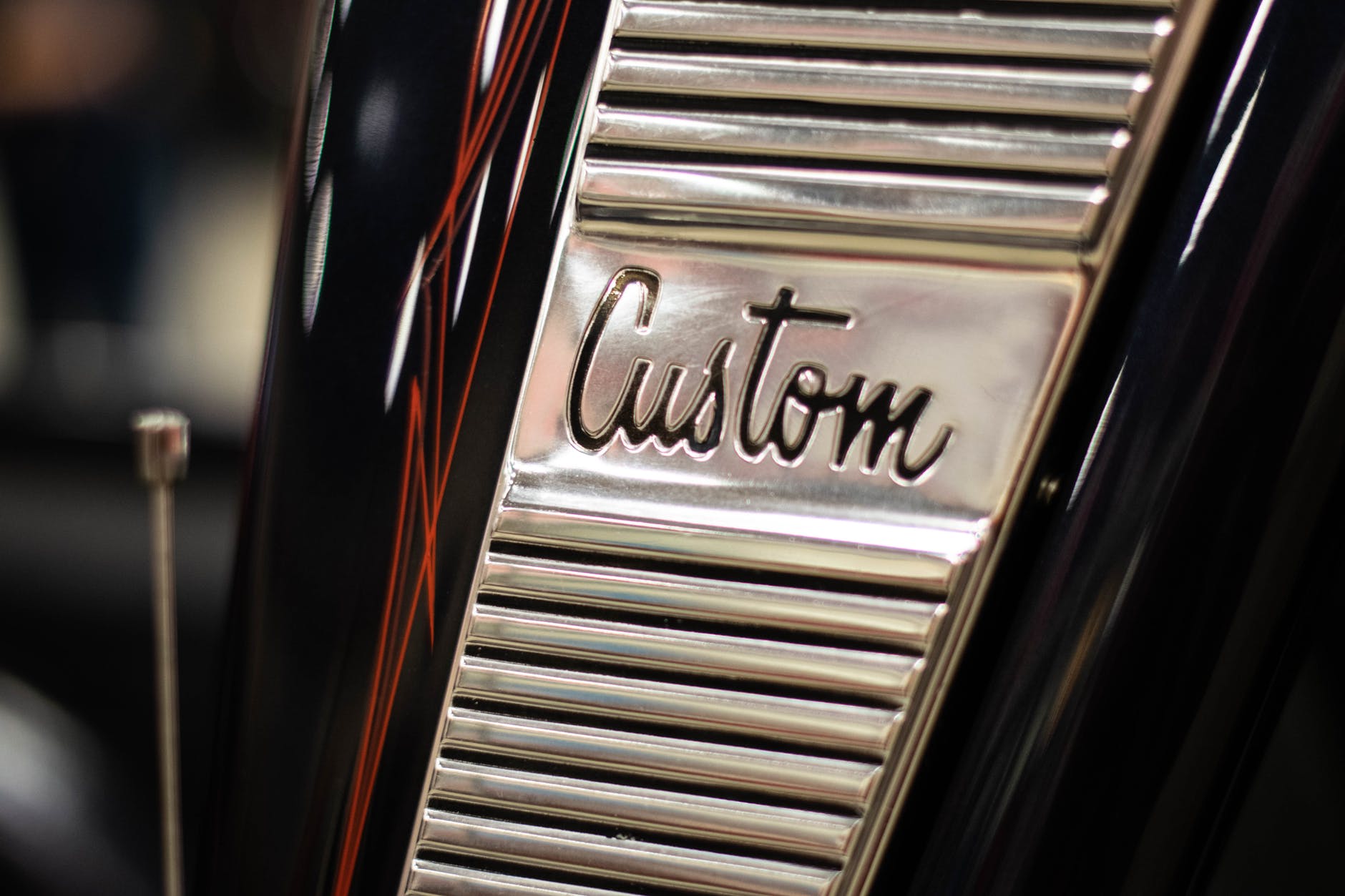 The word 'custom' engraved into metal