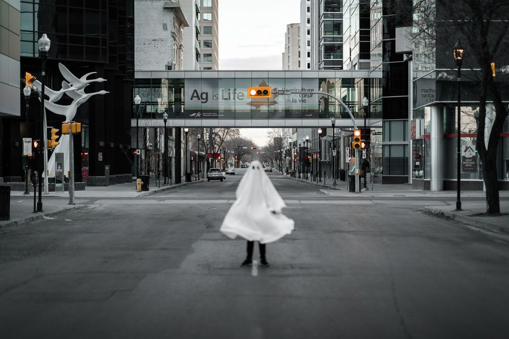 Person dressed as ghost standing on a city street