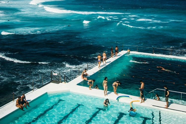 Bathers in a infinity pool surrounded by ocean