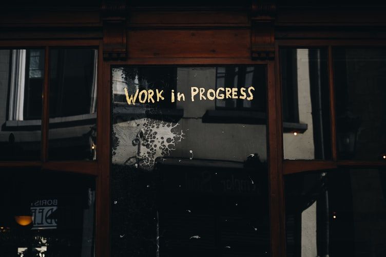 The words 'work in progress' on a glass door
