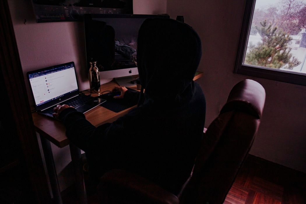 Person using laptop in a gloomy room