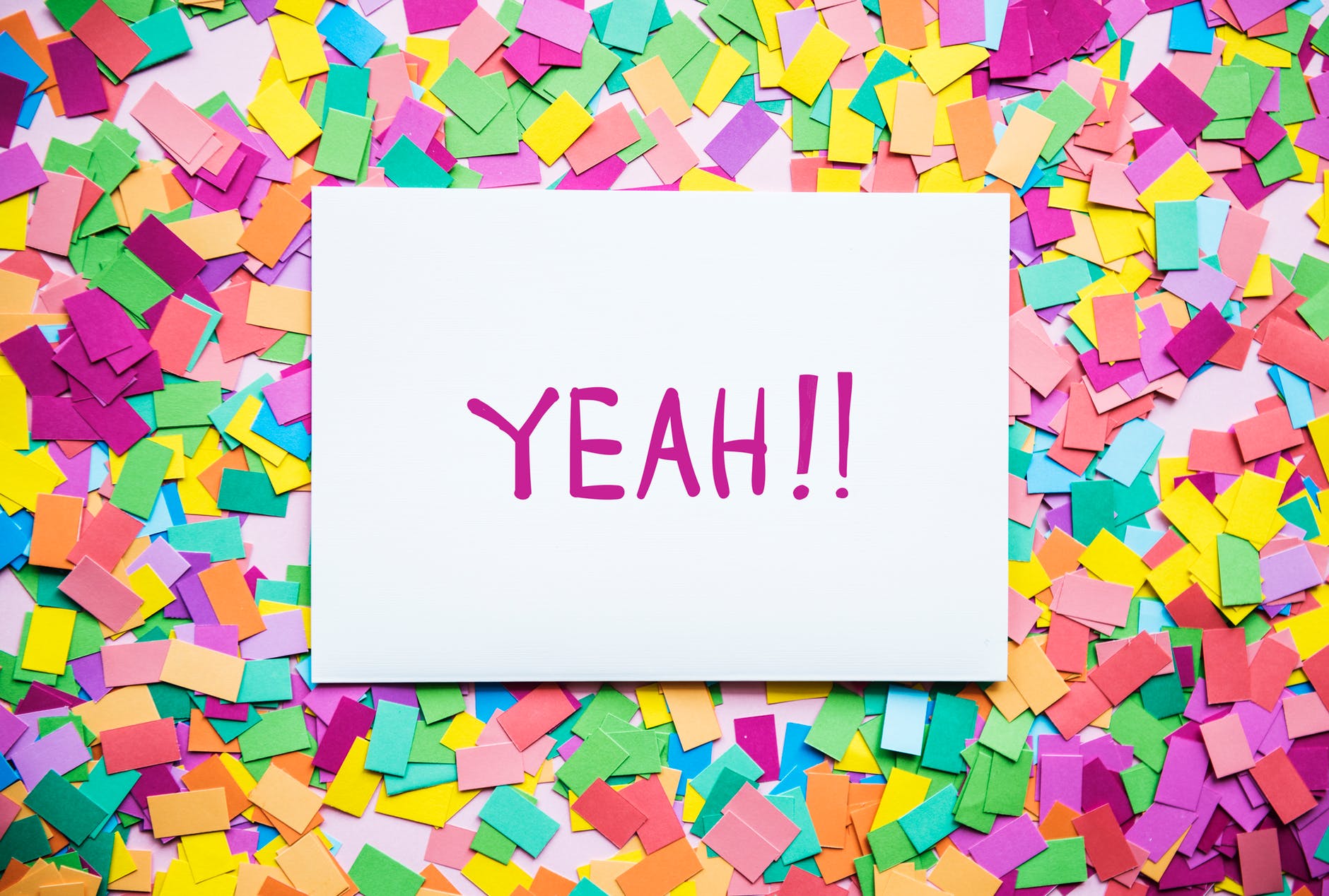 The word 'yeah!!' on a piece of paper surrounded by colorful post-it notes