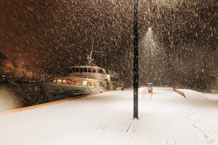 Superyacht moored at a dock in snowy weather