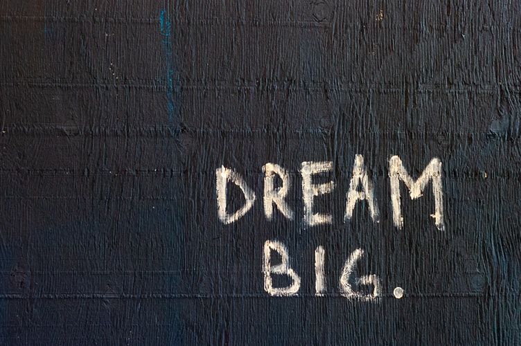 The words 'dream big' painted on a black background