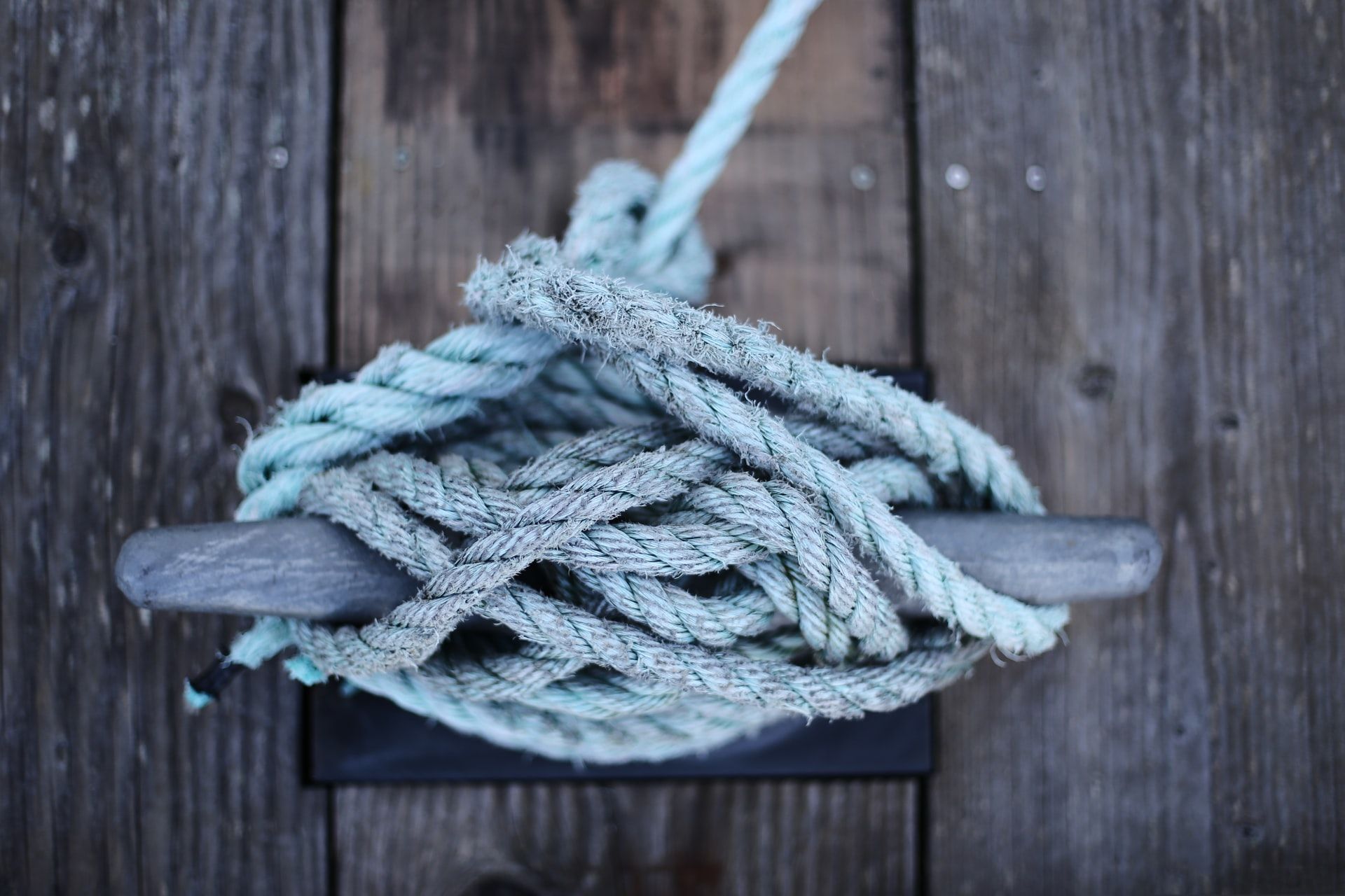 A rope tied around a cleat on a dock