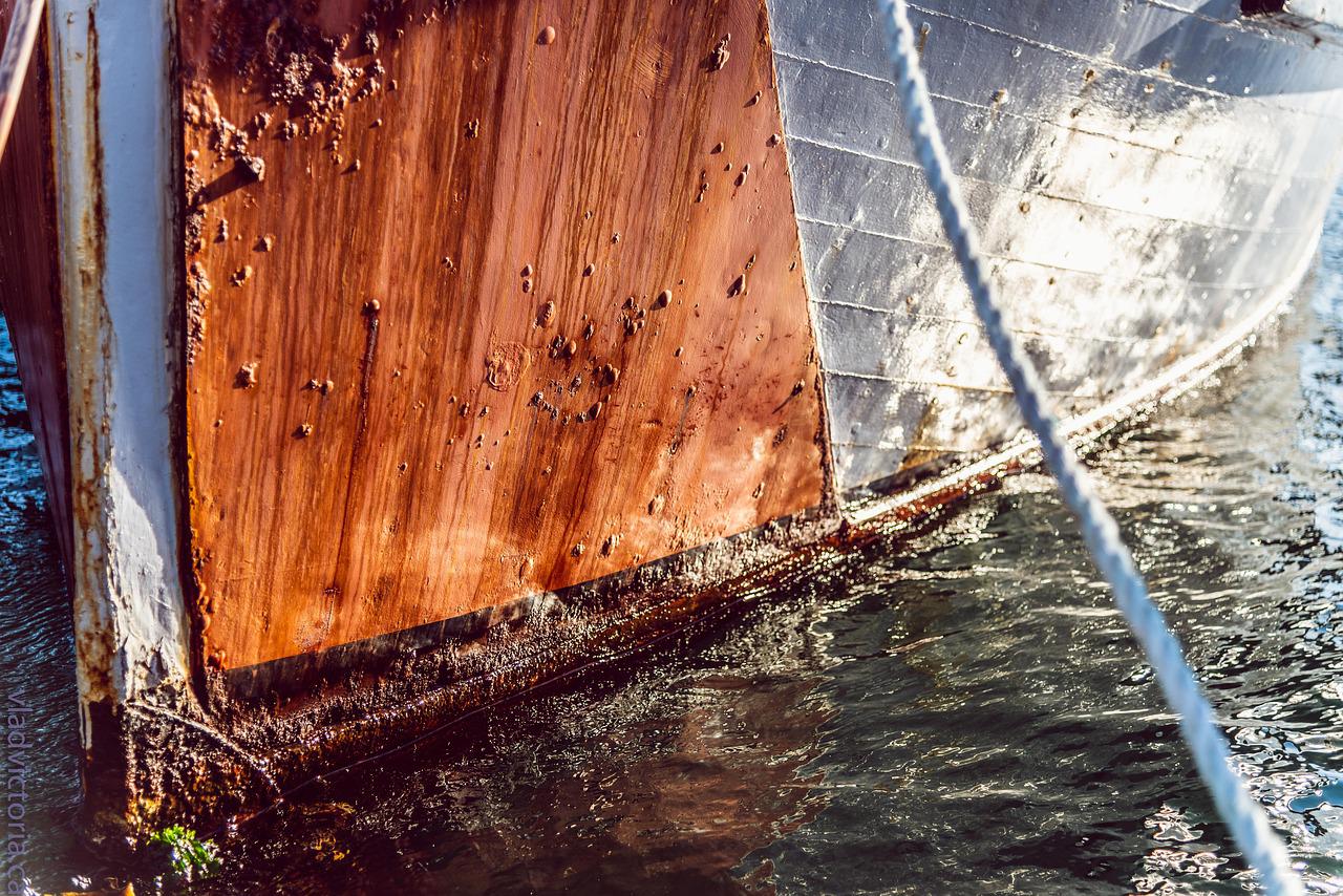 Hull of a boat covered in rust and barnacles