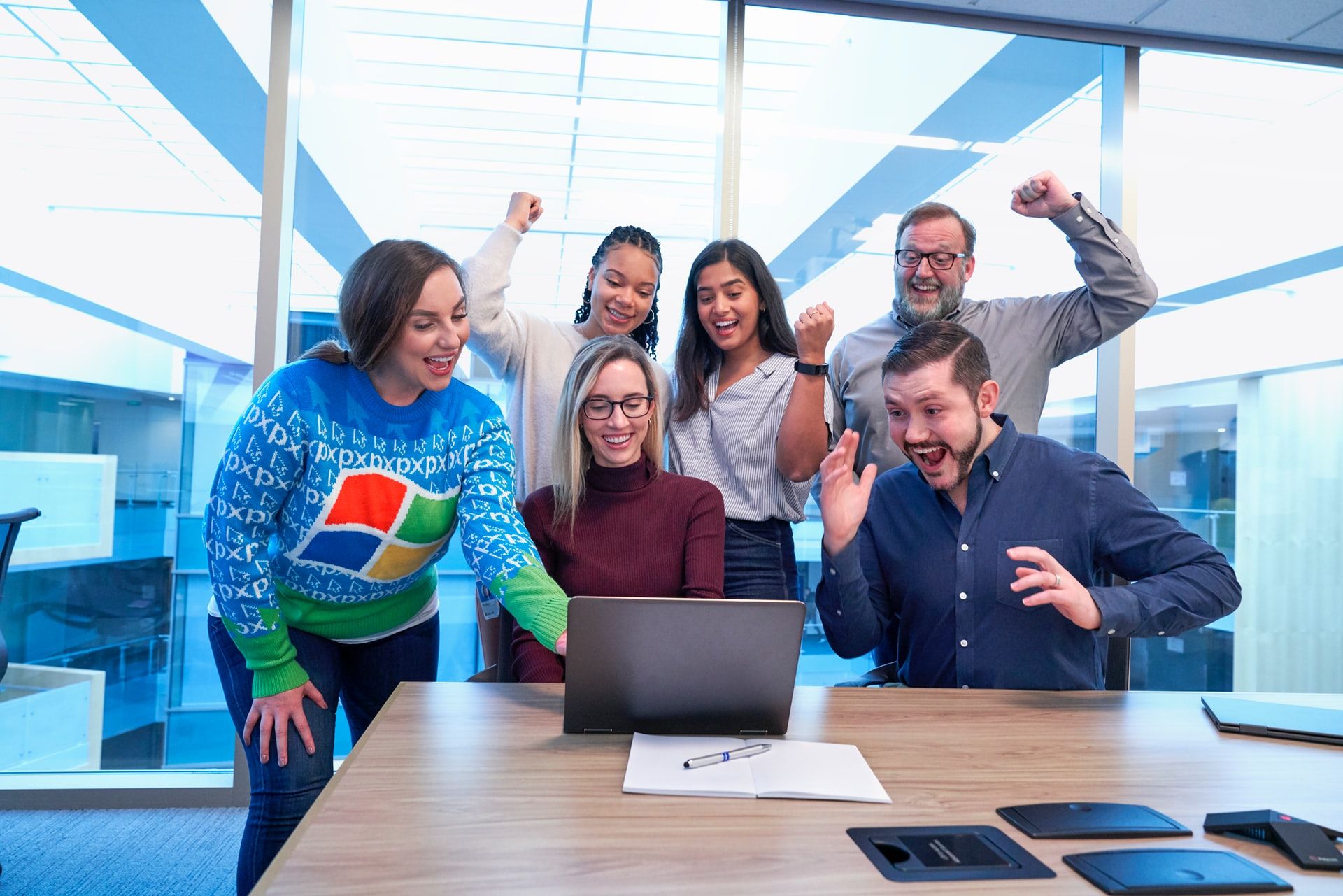 Group of coworkers cheering at a laptop 
