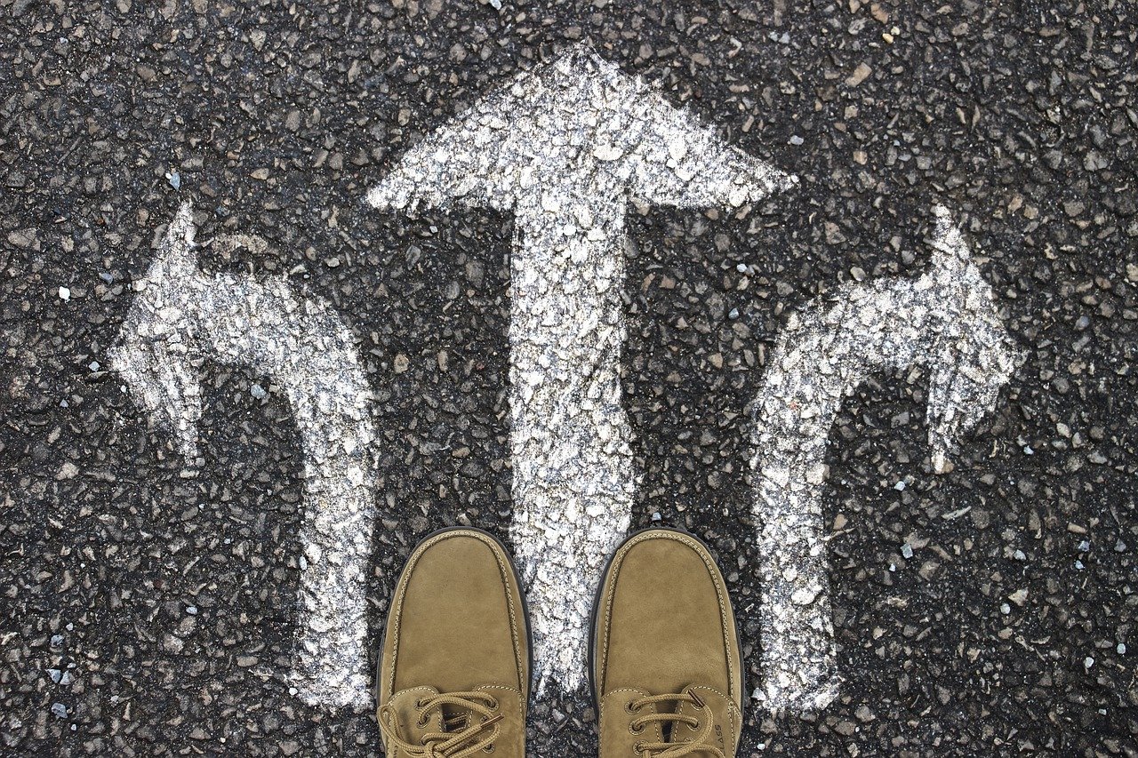 Pair of shoes standing in front of three arrows pointing forward, left and right