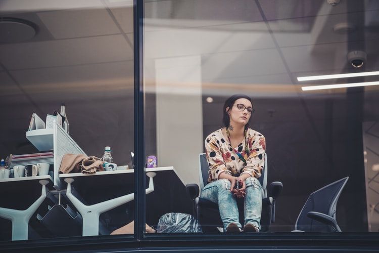 Woman gazing out of an office window looking bored