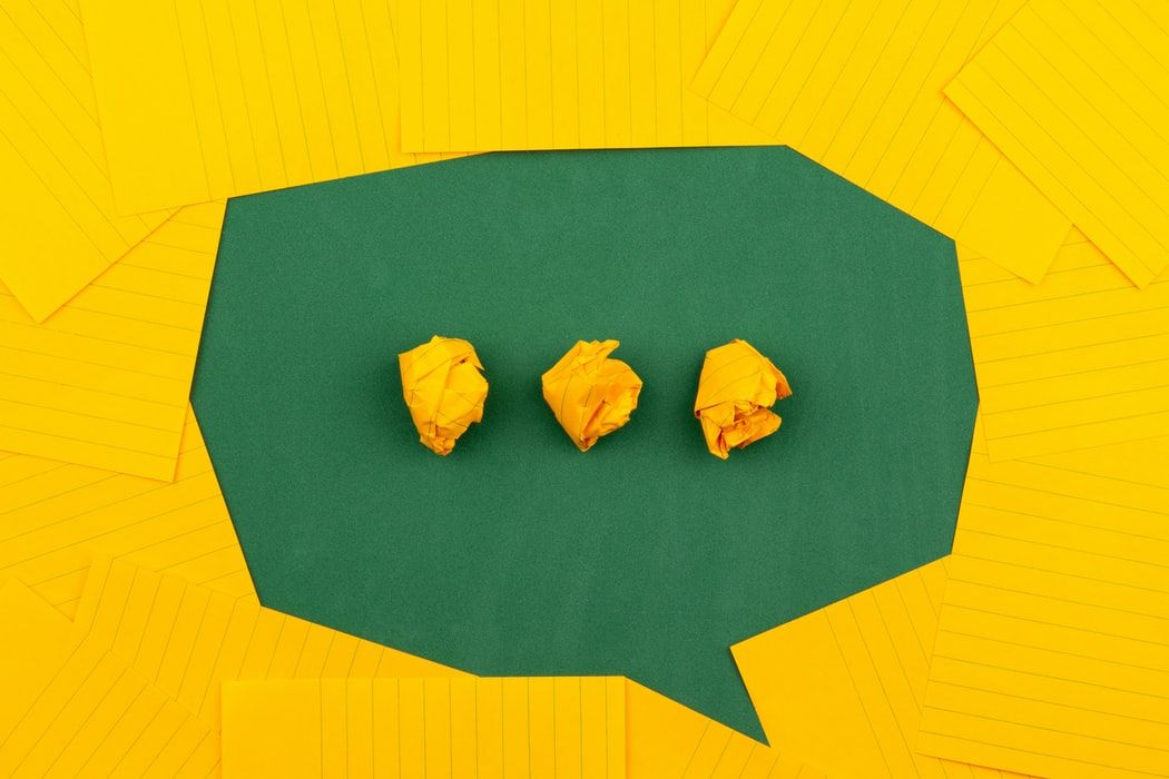 Yellow pieces of paper arrange to form a speech bubble shape