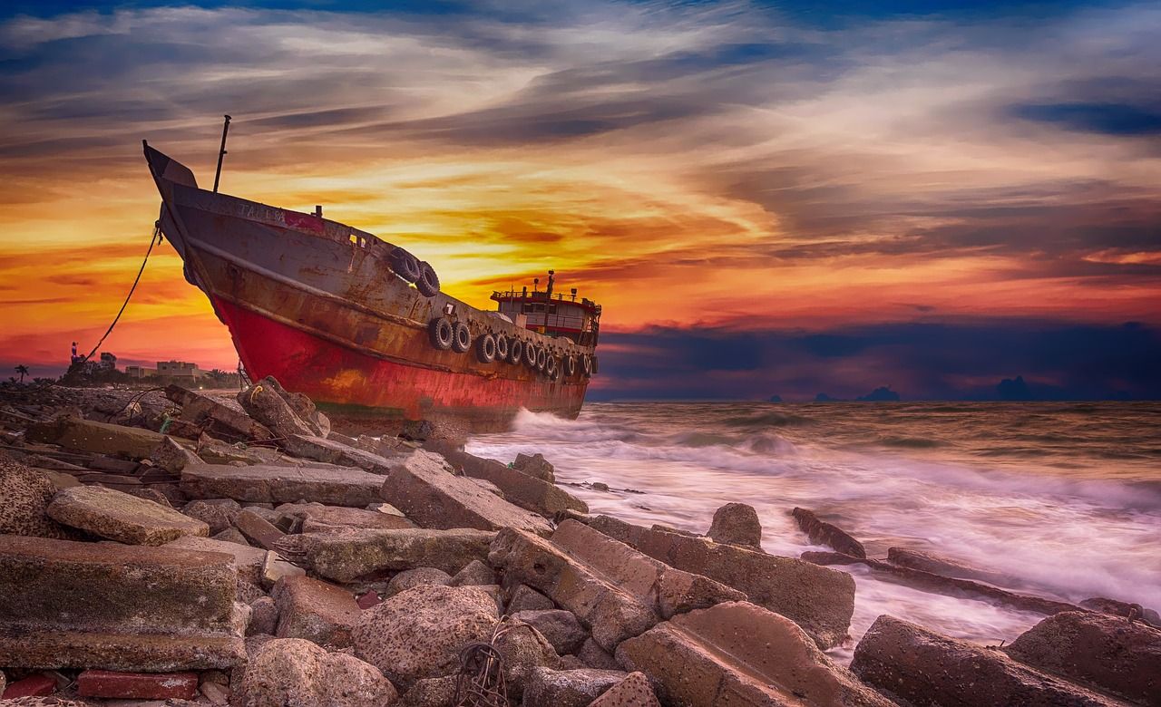 Rusting hull of a shipwreck at sunset