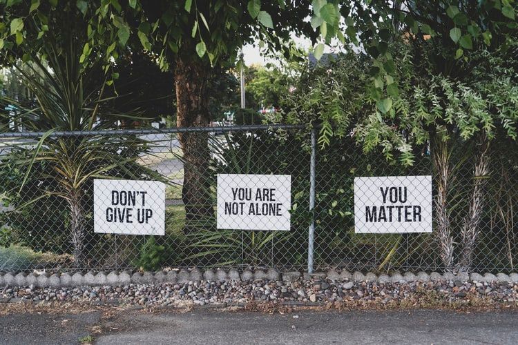 Motivational mental health placards on a fence