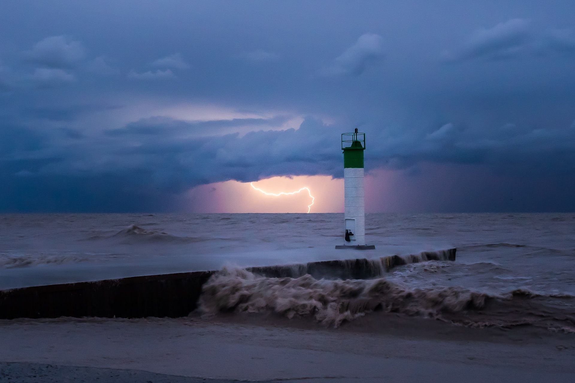 Lightning striking with a lighthouse in the foreground