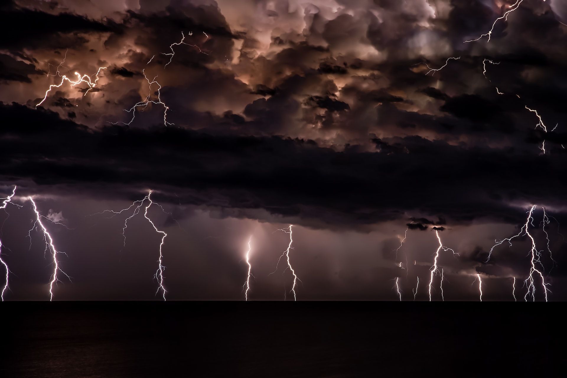 Multiple strikes of forked lightning out at sea