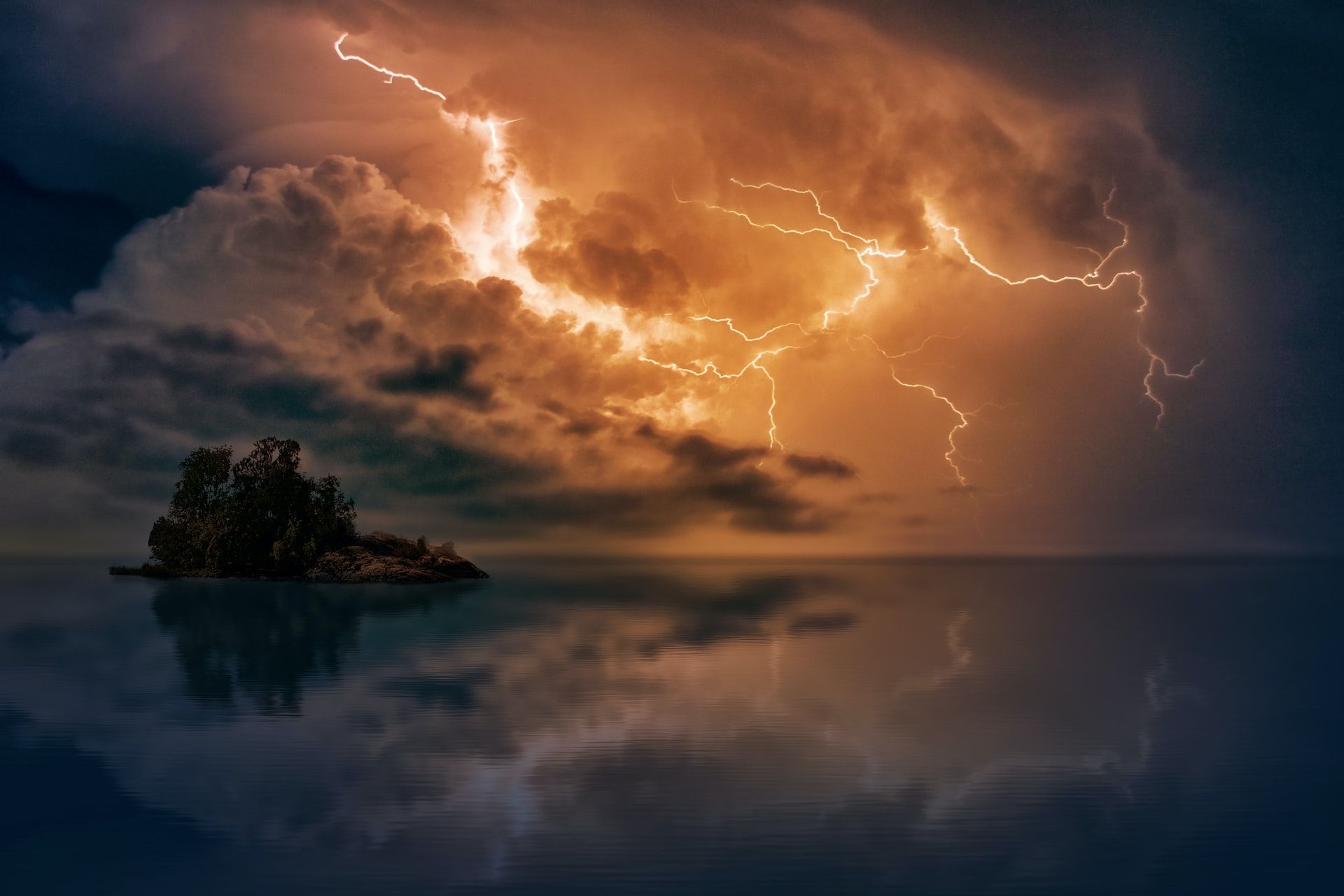 Lightning striking over the ocean and a small island