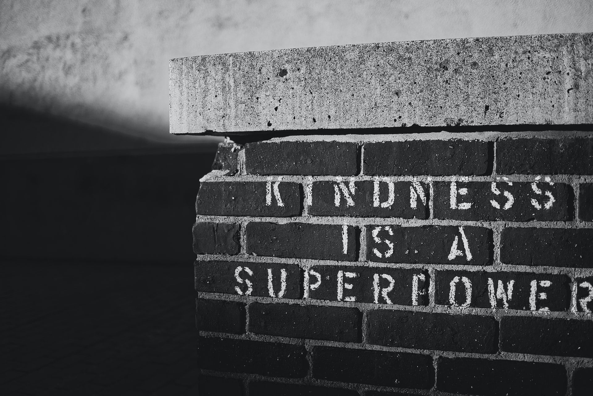 'Kindness is a superpowered' stenciled on a brick wall