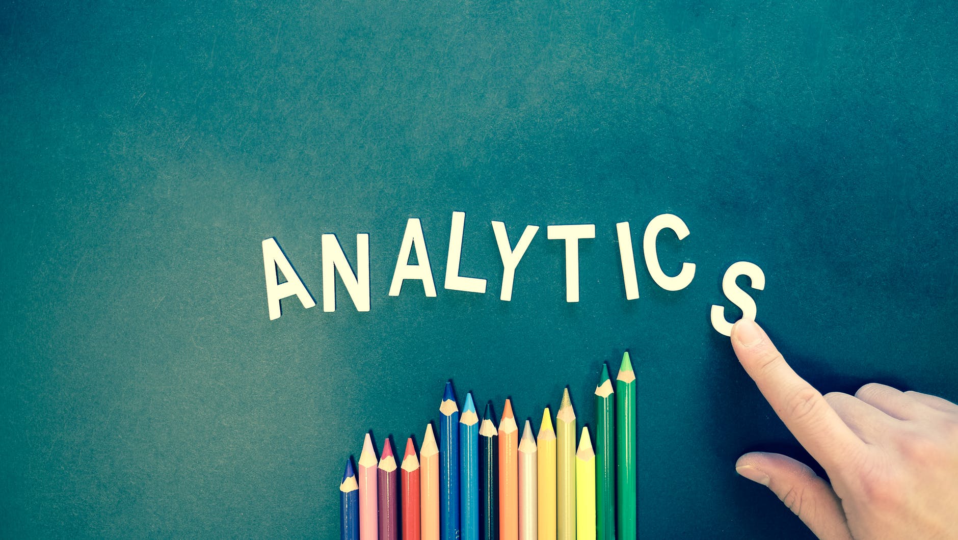 The word analytics and some colored pencils