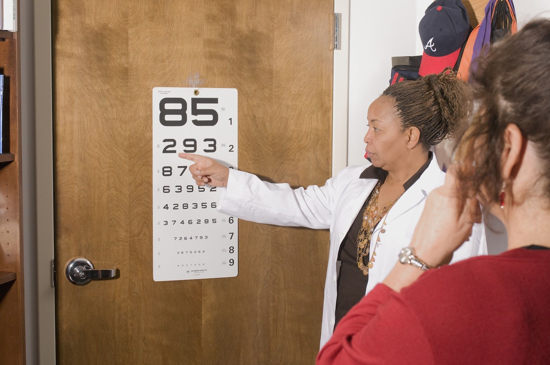 Optician pointing to an eye test poster