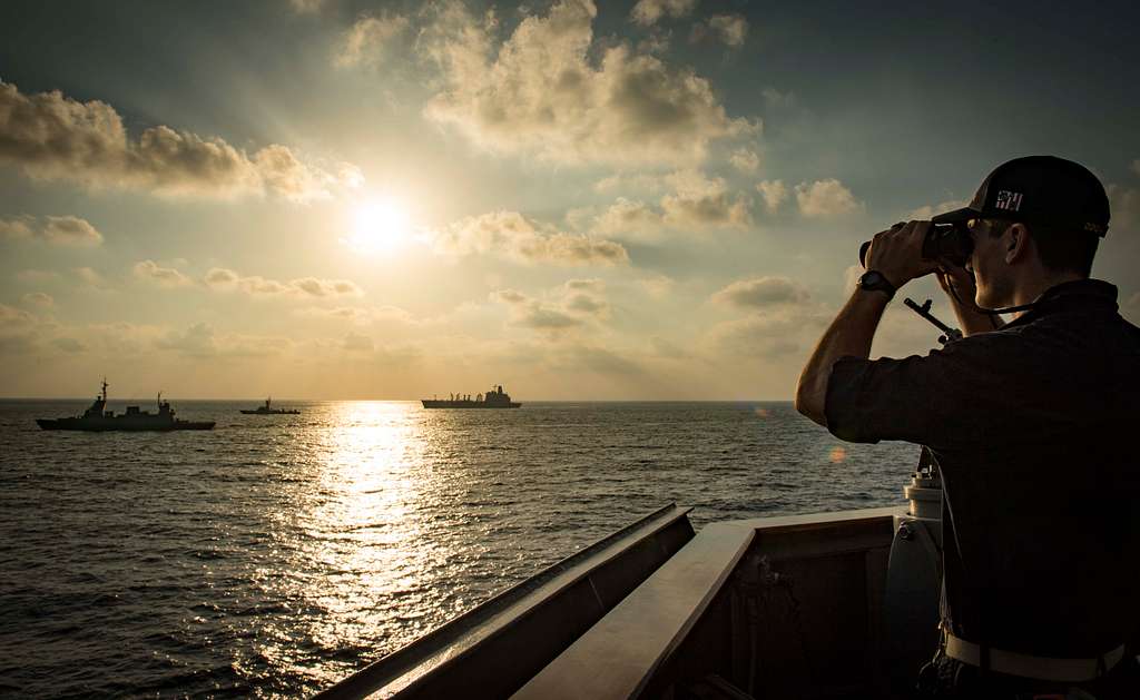 Seafarer using binoculars at dusk
