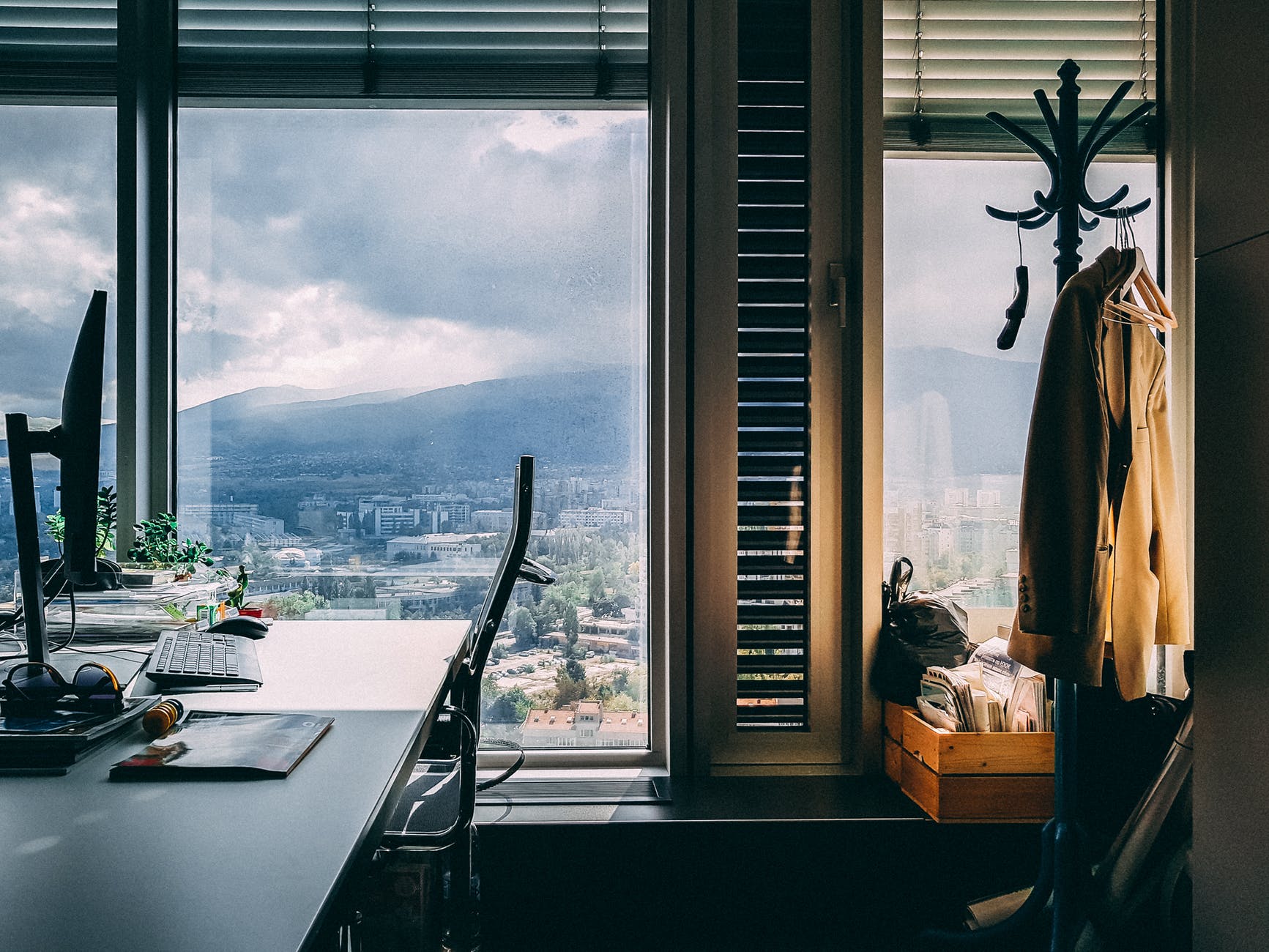 A desk near a window overlooking the city and mountains