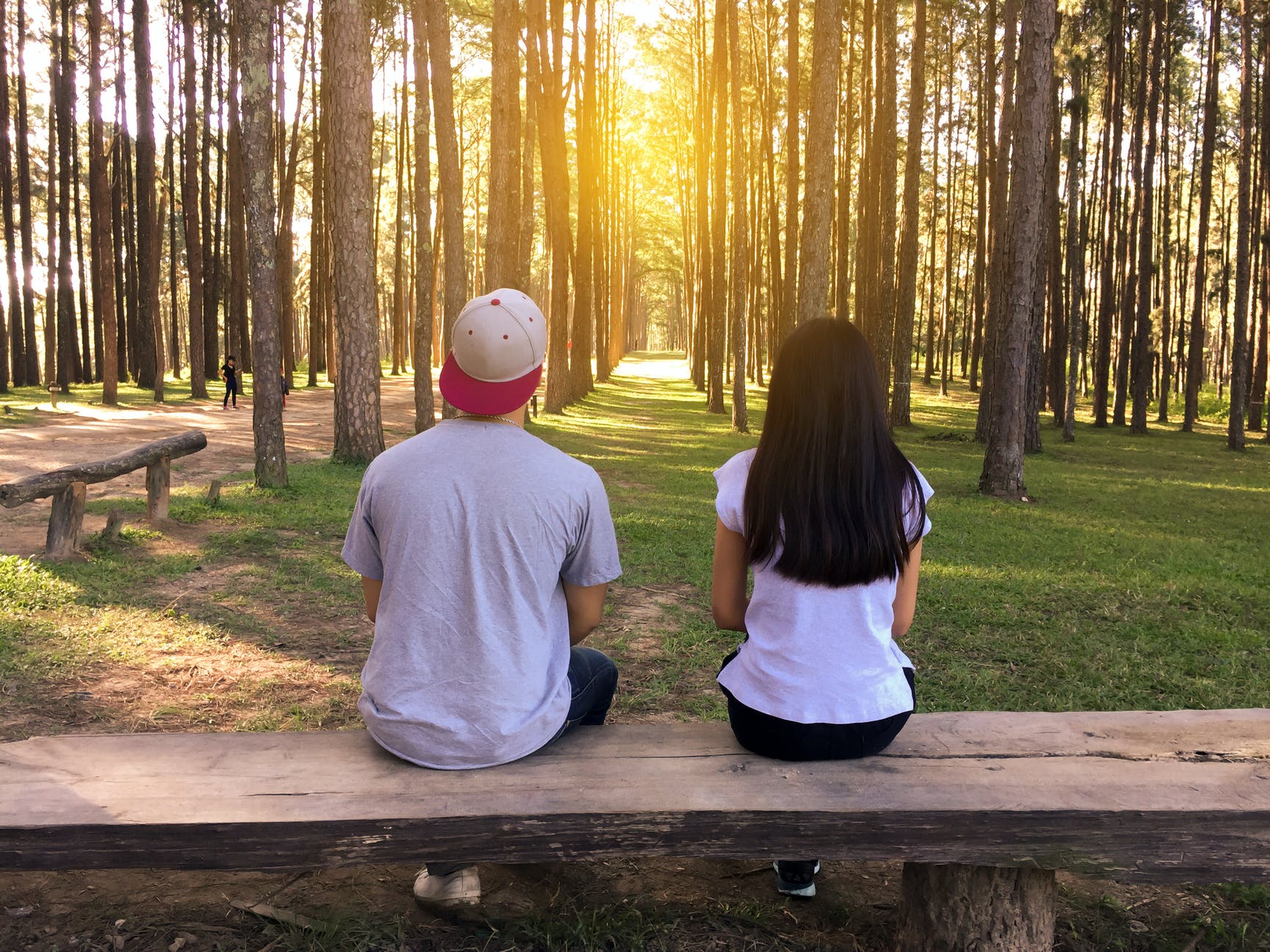 Couple sitting on a bench in a wooded area
