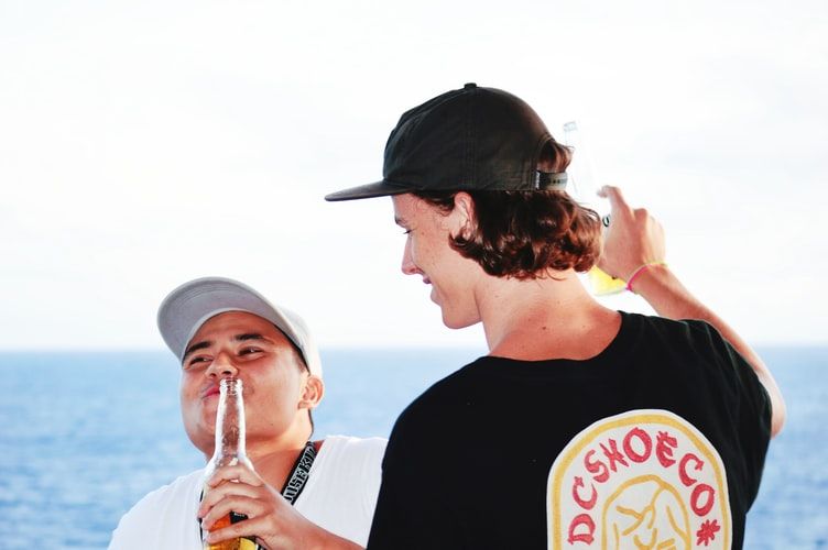 Two guys drinking beer by the sea