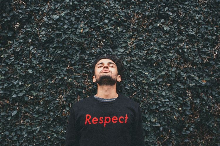 Man wearing a sweater that says 'respect' on it