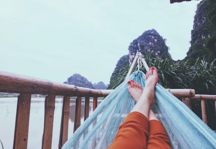 Person lying in a hammock overlooking water