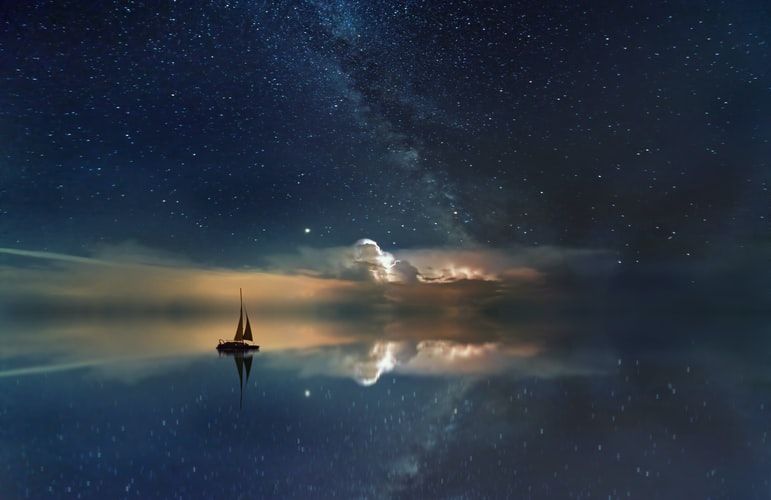 Silhouette of sailing boat under a starry sky