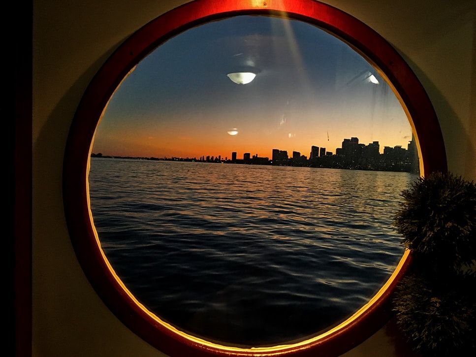 View of a city at sunset through a ship's porthole
