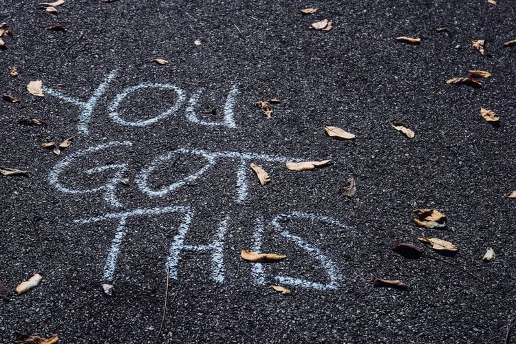 The words 'you got this' written in chalk on tarmac