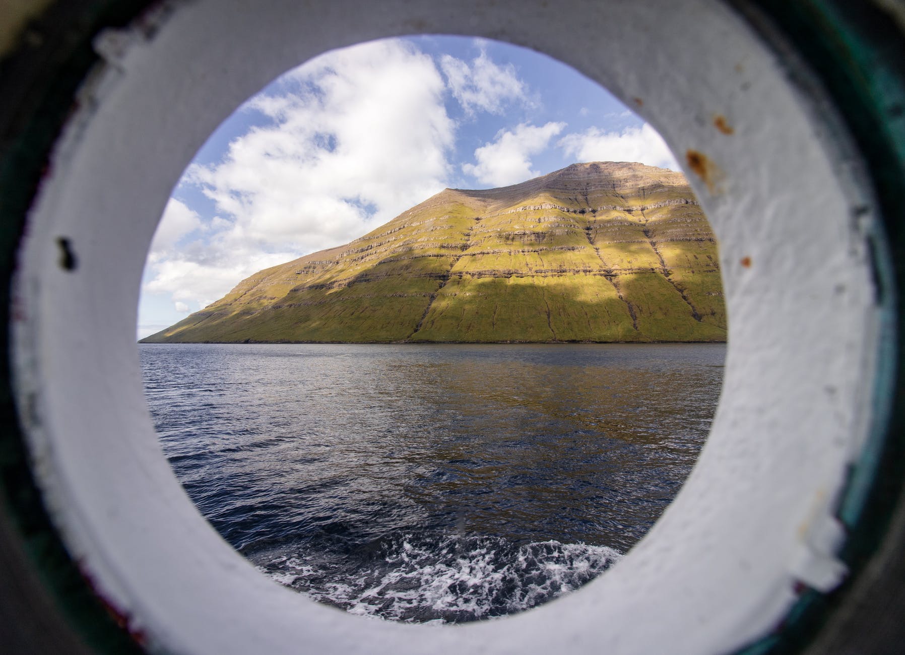 View of hills through a boat's porthole