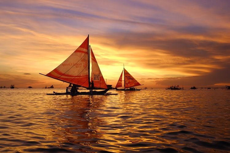 Sailboats with red sails at sunset