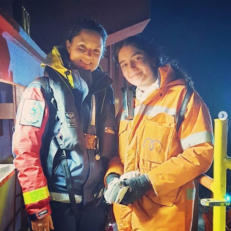 Two female seafarers on deck at night