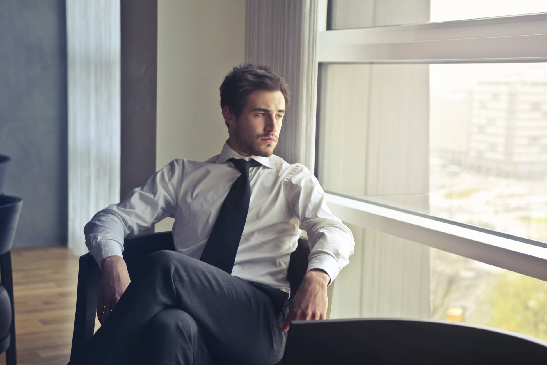 Man in business attire gazing out of an office window