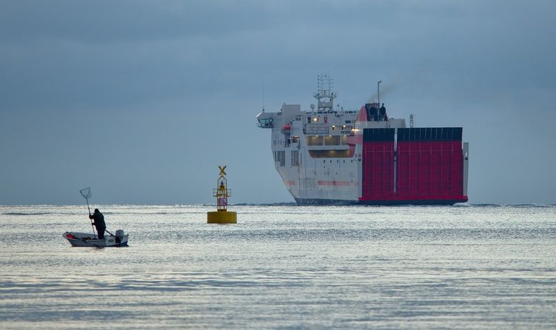 A car carrier vessel, buoy and fishing boat