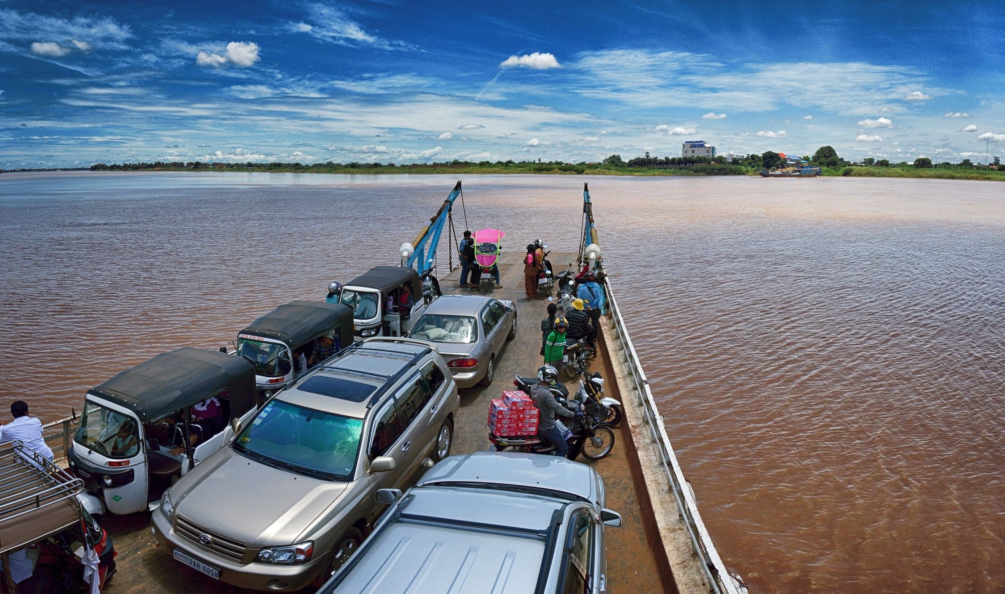 Cars, bikes and tuk tuks on the back of a passenger ferry