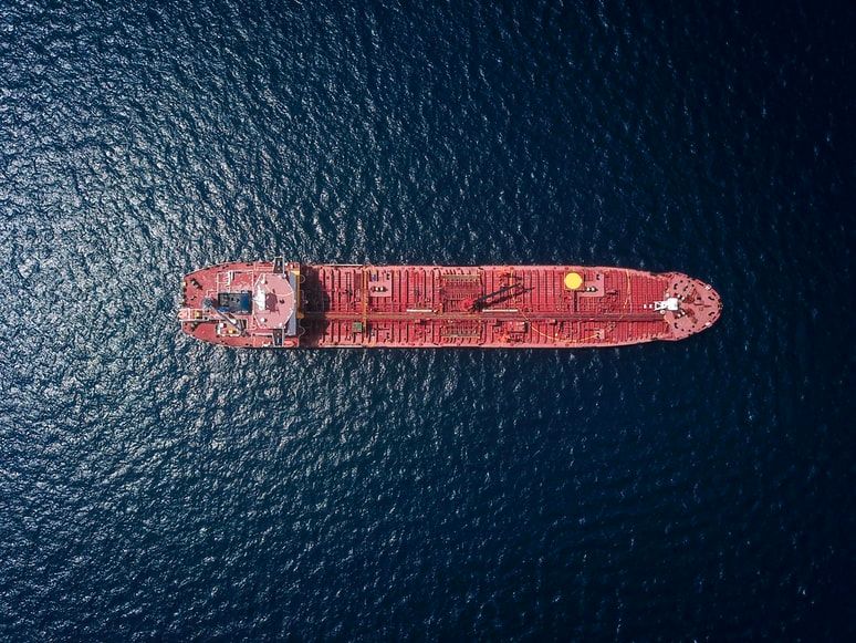 Aerial view of a red oil tanker on a dark blue sea