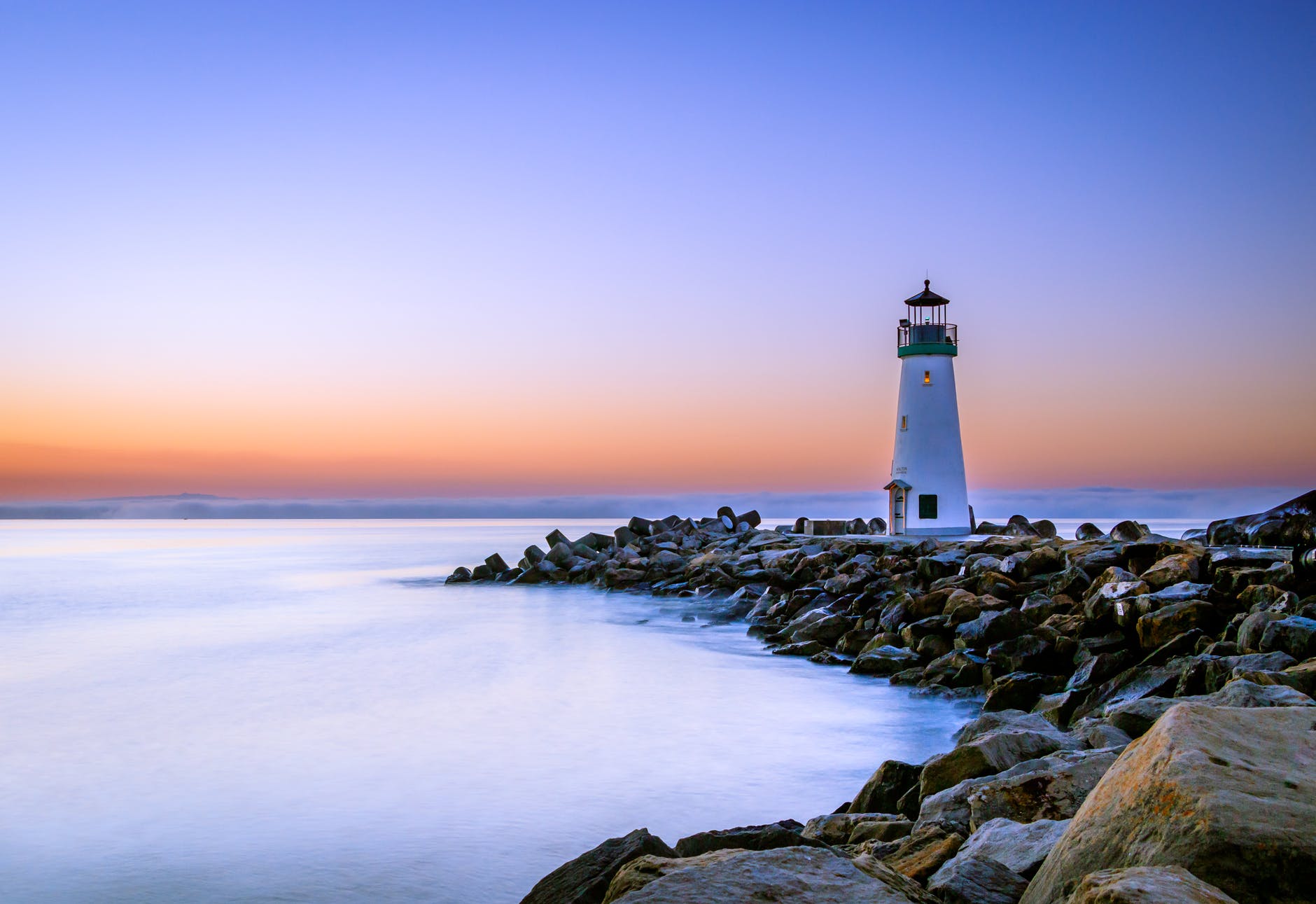 A lighthouse on a rocky point at sundown