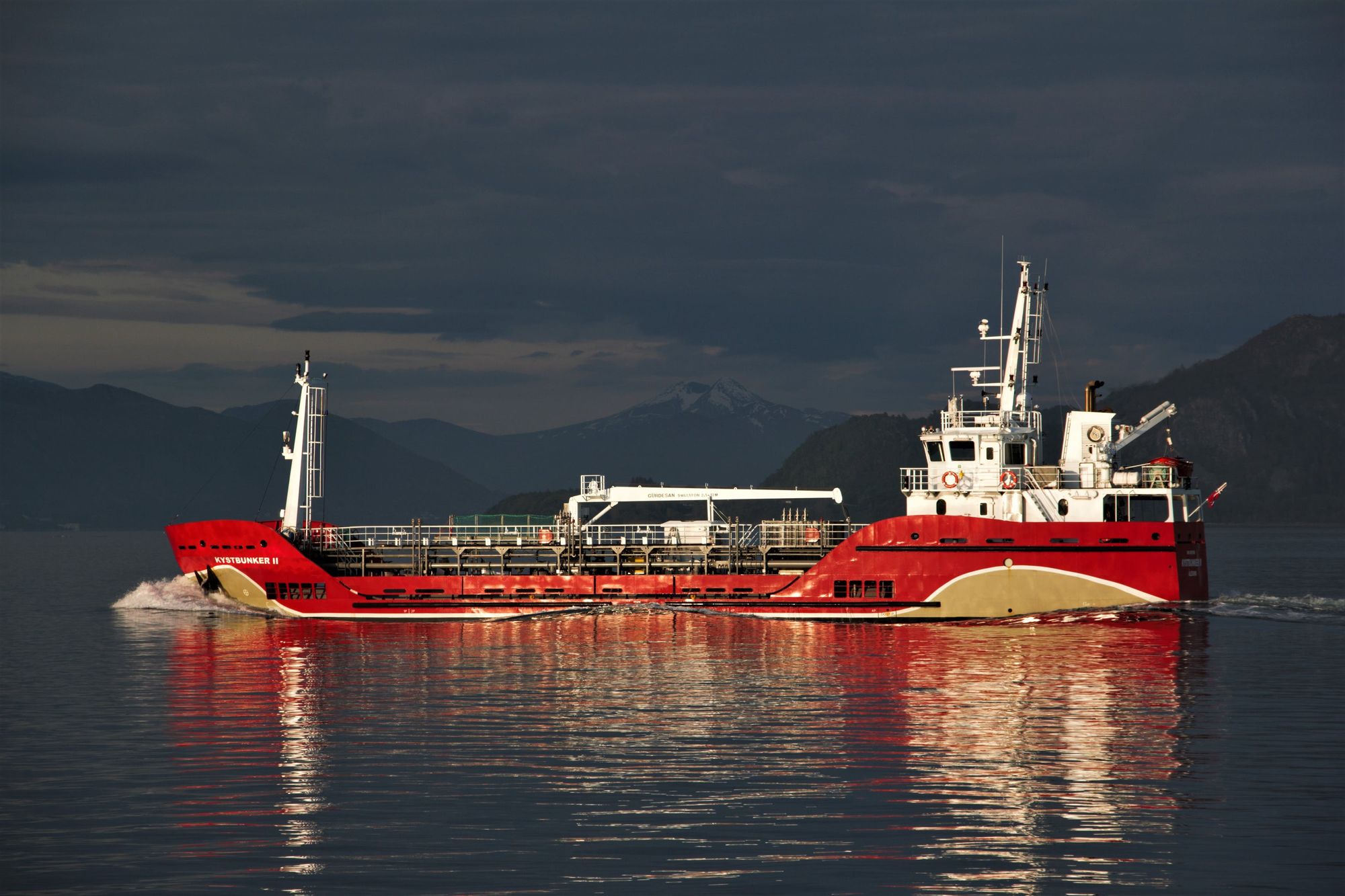 A red and white oil tanker under a grey sky