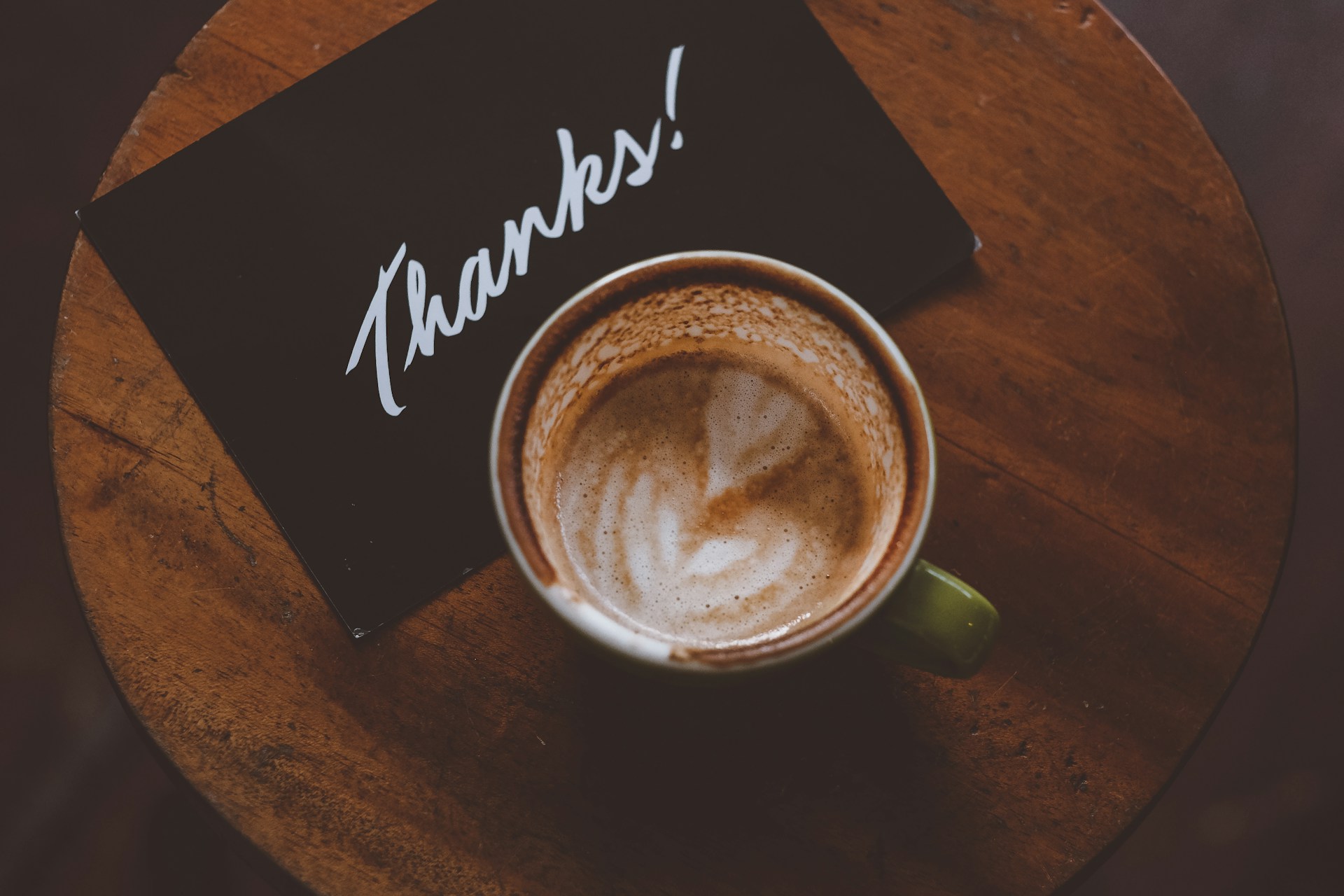 A cup of coffee with a note saying 'thanks'