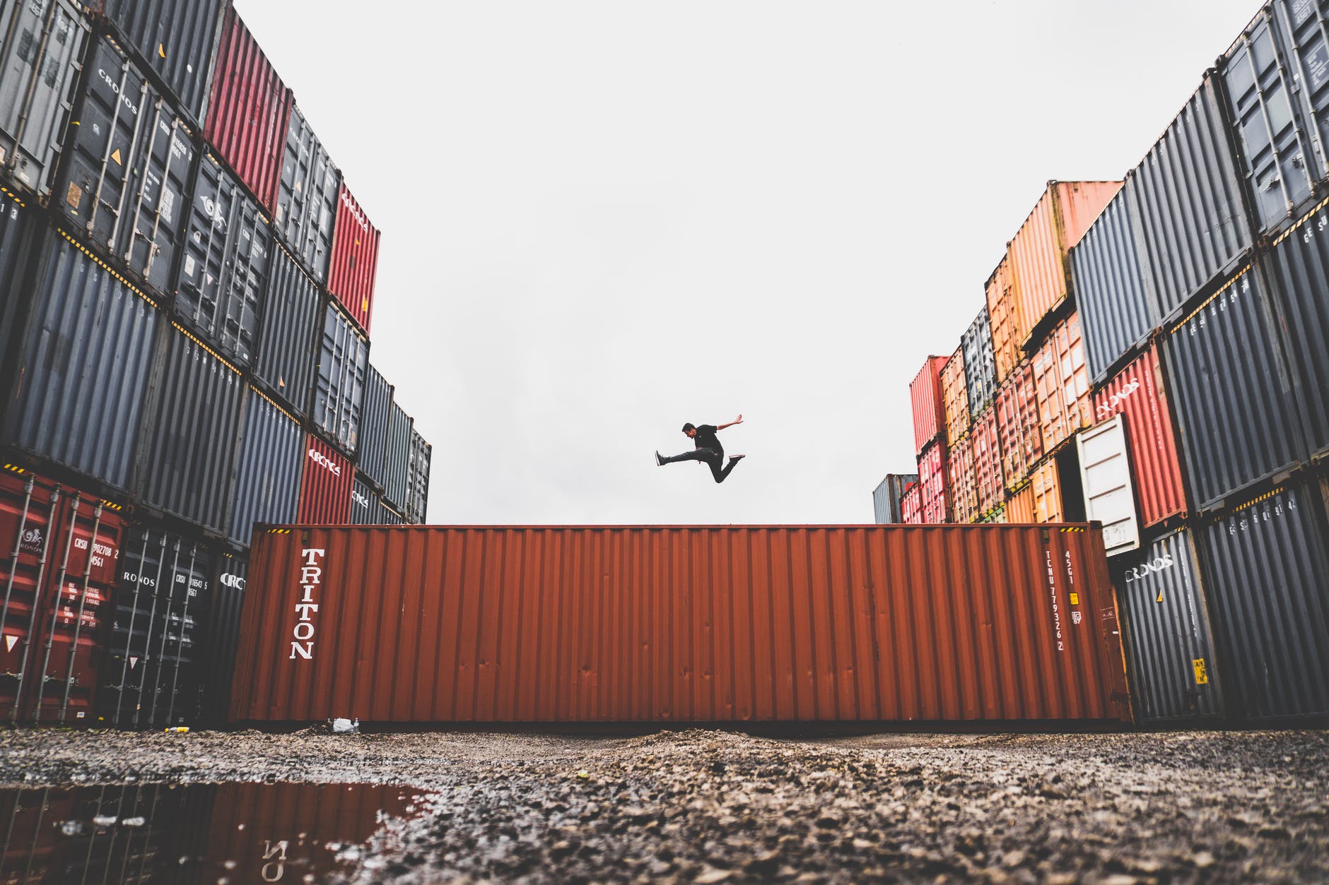 man leaping over shipping containers