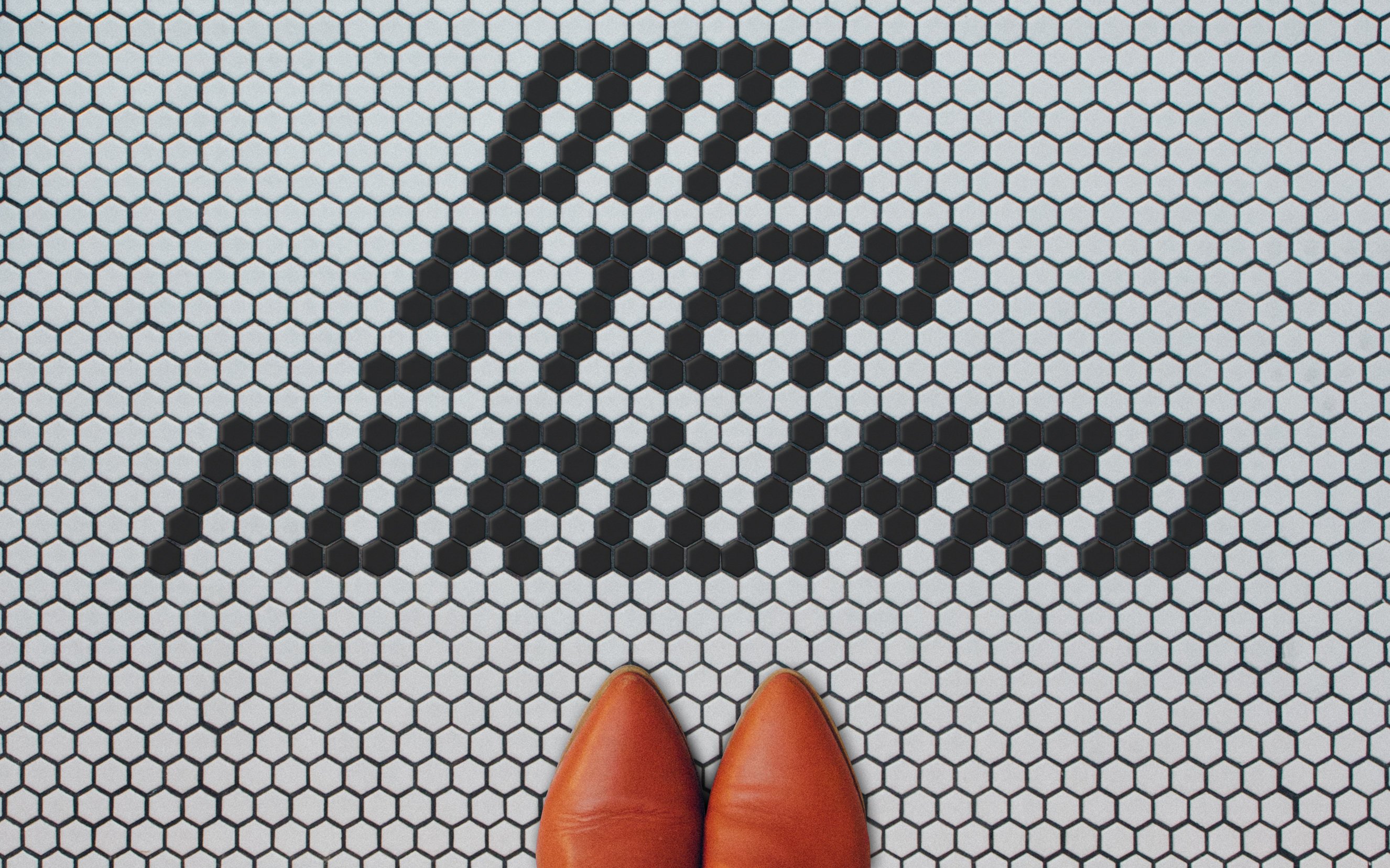 A tiled floor saying 'one step forward' next to a pair of shoes