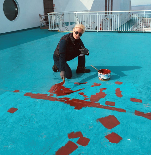 A woman working in a seafarer job that involves deck maintenance