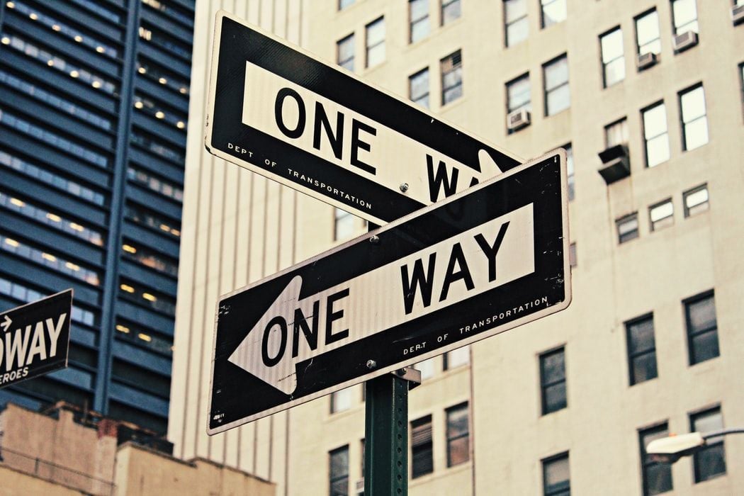 two opposing signs saying one way